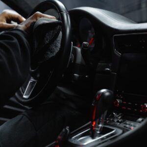 Cleaning car dashboard and steering wheel during interior detail