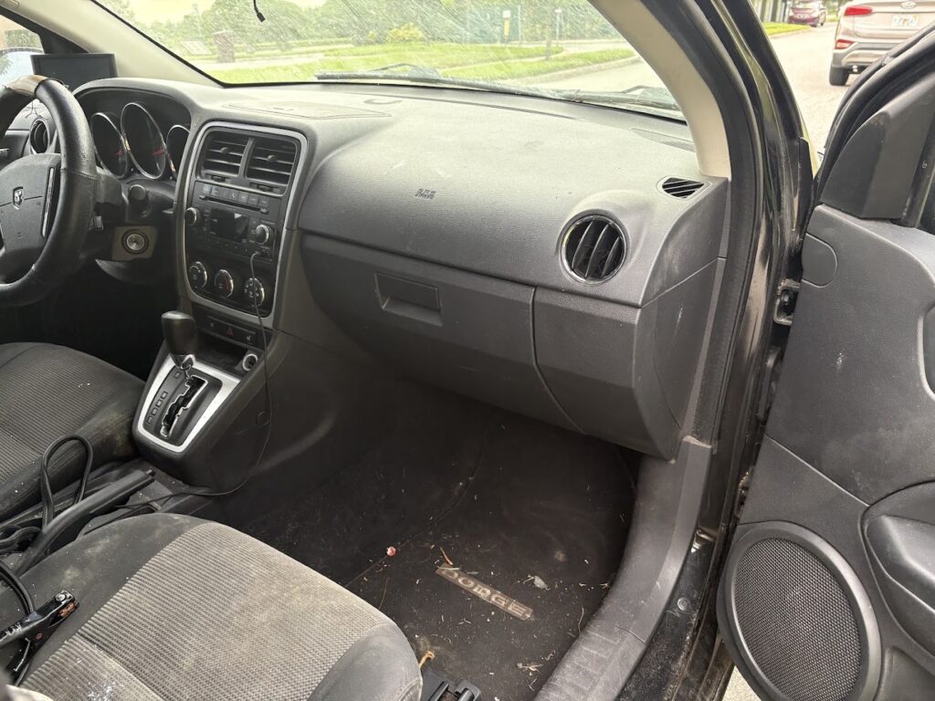Front interior and floor of a 2010 Dodge Caliber before detailing